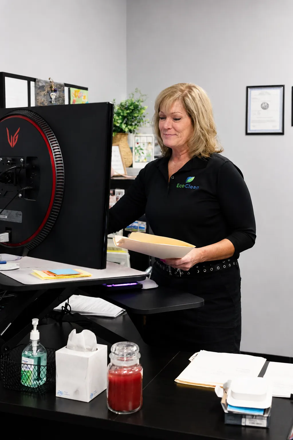 An EcoClean team member organizing paperwork at a desk in the office.