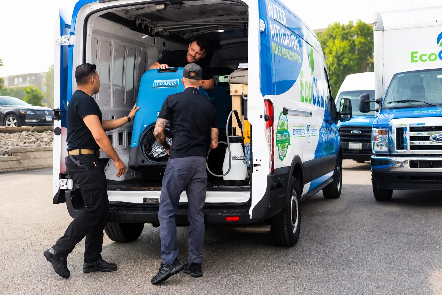 EcoClean crew loading a dehumidifier into the service van.